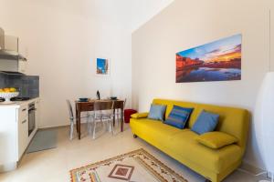 a living room with a yellow couch and a table at Sorelle di Riviera in Syracuse +16 photos