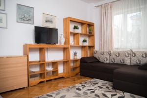 un soggiorno con divano e TV di Apartament David a Călimăneşti