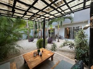 Zen Home, Private community, Wifi, Free Private Parking, Balcony في تولوم: طاولة خشبية في وسط ساحة مع نباتات