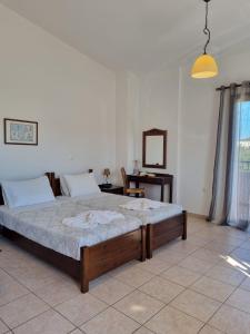 a bedroom with a large bed in a room at Irida Apartments -EX BLAZIS HOUSE in Almirida