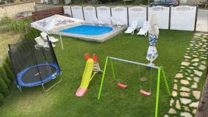 a backyard with a playset and a trampoline at БЯЛАТА КЪЩА in Kirkovo