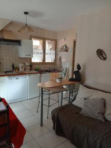 uma cozinha com uma mesa e um sofá num quarto em Le Cigalou em Sainte-Croix-de-Verdon
