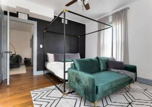 Luxury 2 Bedroom Apartment In Jacksonville في جاكسونفيل: غرفة معيشة مع أريكة خضراء وسرير