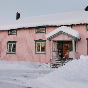 ein rosa Haus mit Schnee auf der Vorderseite in der Unterkunft Private Room in Pink House in Pajala