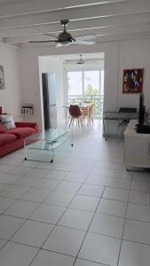 uma sala de estar com um sofá vermelho e uma mesa em Appartement T3 vue mer sur ilet Gosier em Le Gosier