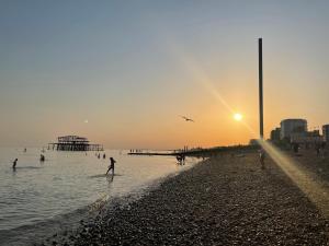 Un groupe de gens jouant dans l'eau à la plage dans l'établissement Seafront Medina, à Brighton et Hove