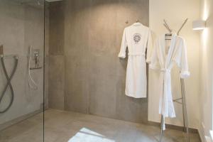 a white robe hanging on a wall in a bathroom at MeerVerliebt B in Hörnum +37 photos