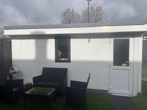 awning over a patio with chairs and a table at Beautiful place to live near Heathrow Windsor Legoland & Free Parking Onsite in Burnham