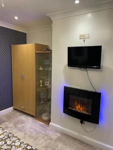 a living room with a fireplace and a tv on the wall at Beautiful place to live near Heathrow Windsor Legoland & Free Parking Onsite in Burnham