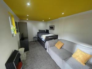 a living room with a couch and a bed at Beautiful place to live near Heathrow Windsor Legoland & Free Parking Onsite in Burnham