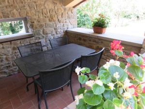 a black table and chairs on a patio at La Luna Nel Pozzo in Castiglion Fibocchi