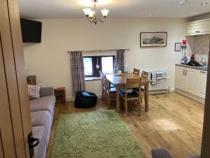 a kitchen and living room with a table and a couch at Greystones in Milnthorpe