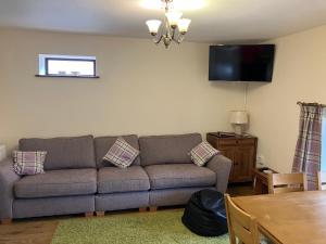 a living room with a couch and a flat screen tv at Greystones in Milnthorpe