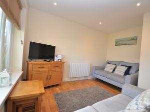 a living room with a couch and a flat screen tv at 2 Bed in Brixham BX081 in Brixham