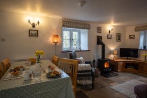 ein Wohnzimmer mit einem Tisch und einem Kamin in der Unterkunft Wavering in Axbridge