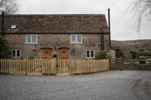 a brick house with a wooden fence in front of it at Wavering in Axbridge