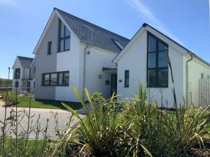 a white house with black windows at 4 Bed in Westward Ho 75358 in Northam