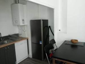 uma cozinha com um frigorífico preto e uma mesa em Beautiful and bright 1st Floor Flat with large Terrace - Biarritz City Center em Biarritz