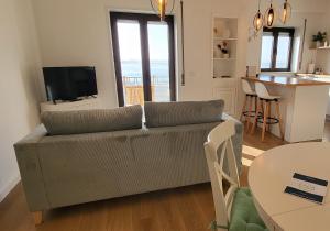 uma sala de estar com um sofá e uma mesa em SonhosQrodopiam Praia da Barra em Praia da Barra