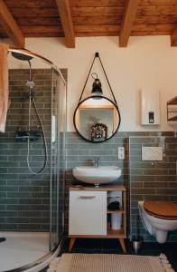 ein Bad mit einer Dusche, einem Waschbecken und einem Spiegel in der Unterkunft Ferienhaus Vandra in Eisenach