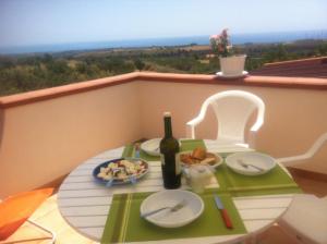 a table with a bottle of wine and a plate of food at Pezzino Green Home in Agrigento