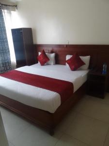 a bedroom with a large bed with red pillows at Deka hotel Nairobi in Thika