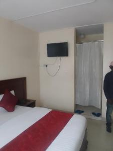1 dormitorio con 1 cama y TV en la pared en Deka hotel Nairobi, en Thika