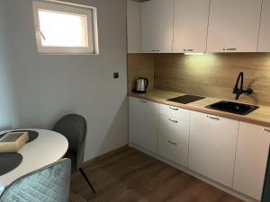 a kitchen with white cabinets and a table at Mimsy house in Plovdiv