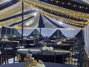 une tente de mariage avec des tables, des chaises et des lumières dans l'établissement Luckyone Hotel, à Lilongwe