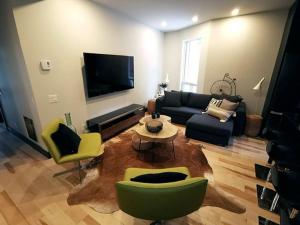 een woonkamer met een bank en stoelen en een tv bij Private room & Private bathroom in le Plateau in Montreal