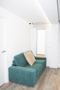 un sofá verde en una habitación con paredes blancas en Deluxe A2 Centro Pozuelo de Alarcón en Pozuelo de Alarcón
