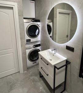 a bathroom with a sink and a washer and dryer at Slenio Apartamentai in Kaunas