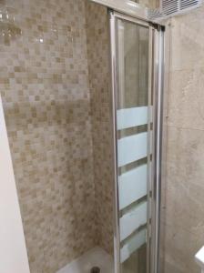 y baño con ducha y puerta de cristal. en La casita de la abuela, en Málaga