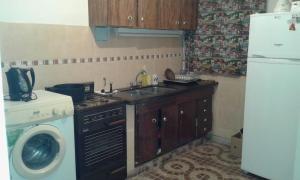 a kitchen with a sink and a washing machine at Sierras Chicas La Granja in Córdoba