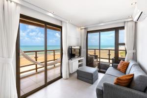a living room with a view of the beach at Beach front Varandas Do Mar in Cumbuco +70 photos