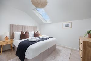 um quarto com uma cama grande e uma clarabóia em 2 Bed - Penthouse The Gatehouse by Pureserviced em Plymouth