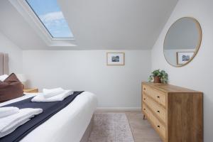 a bedroom with a bed and a mirror and a dresser at 2 Bed - Penthouse The Gatehouse by Pureserviced in Plymouth