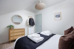 um quarto com uma cama com lençóis brancos e um espelho em 2 Bed - Penthouse The Gatehouse by Pureserviced em Plymouth