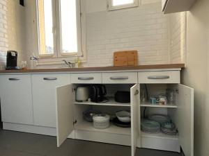uma cozinha com um lavatório e um balcão com pratos em Grand Paris cocooning à 5 minutes de la gare em Pavillons-sous-Bois