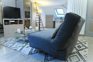 ein Wohnzimmer mit einem blauen Sofa und einem Tisch in der Unterkunft DUPLEX SPACIEUX TOUT CONFORT in Mulhouse