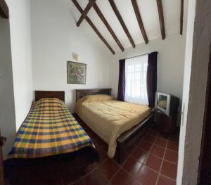1 dormitorio con 1 cama y TV. en Acogedora casa en Villa de Leyva, en Villa de Leyva