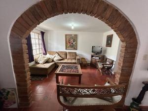 een woonkamer met een boog met een bank en een tafel bij Acogedora casa en Villa de Leyva in Villa de Leyva