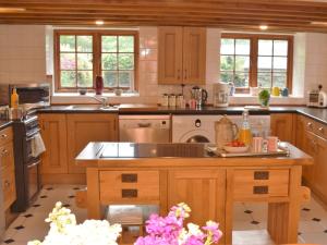 a large kitchen with wooden cabinets and a sink at 3 Bed in Boscastle 75145 in Boscastle