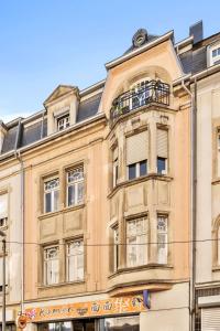 ein Gebäude mit Balkon darüber in der Unterkunft Luminous Luxe - White and Gold in Luxemburg (Stadt)