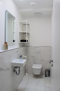 a white bathroom with a sink and a toilet at Komfortables Penthouse 200 qm in Langen