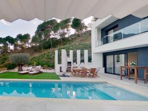a villa with a swimming pool and a house at Premium Habitat 3 Hermanas in Sant Andreu de Llavaneres