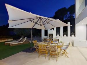 a table with a large umbrella on a patio at Premium Habitat 3 Hermanas in Sant Andreu de Llavaneres