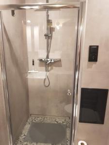a shower with a glass door in a bathroom at Apartament Chrobry in Kętrzyn