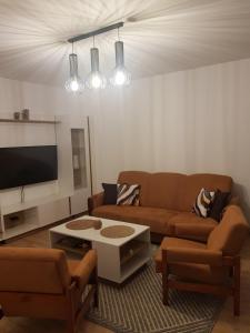 a living room with a couch and a tv at Apartament Chrobry in Kętrzyn