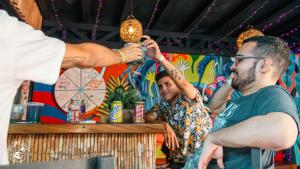 Um homem a beber num bar. em Surf Town Hostel em San Juan del Sur